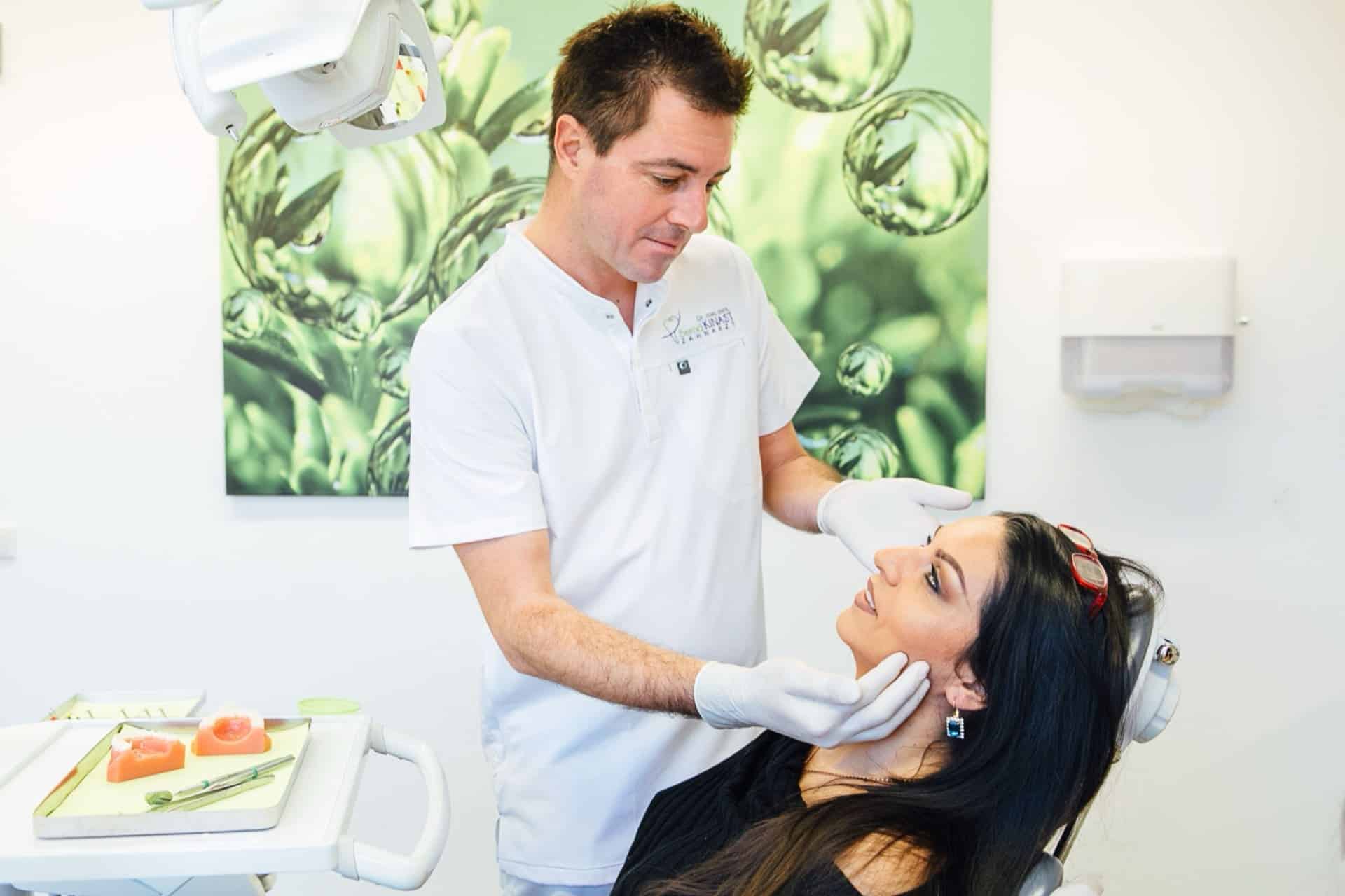 Dr. Bernd Kinast untersucht einen Patienten im Behandlungsraum.