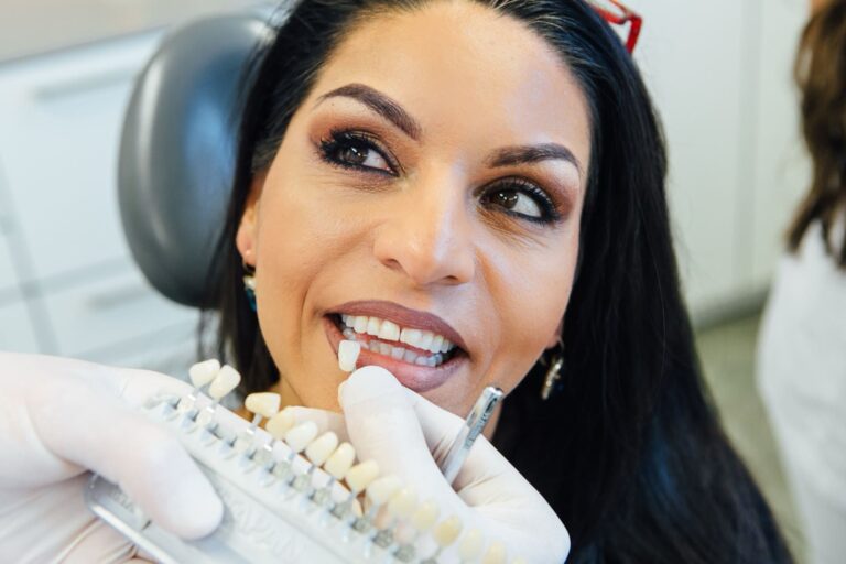 Abgleich der Zahnfarbe bei einer Patientin mit Hilfe von Zahnfarbmustern.